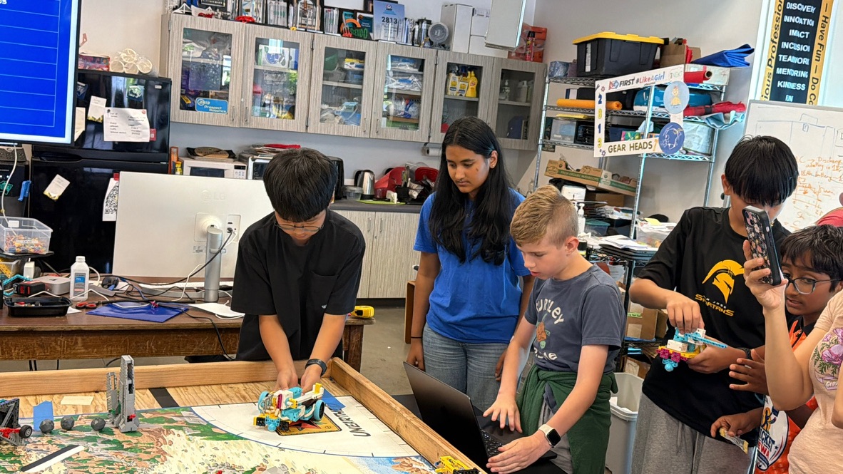 Khushi helping students test an FLL robot